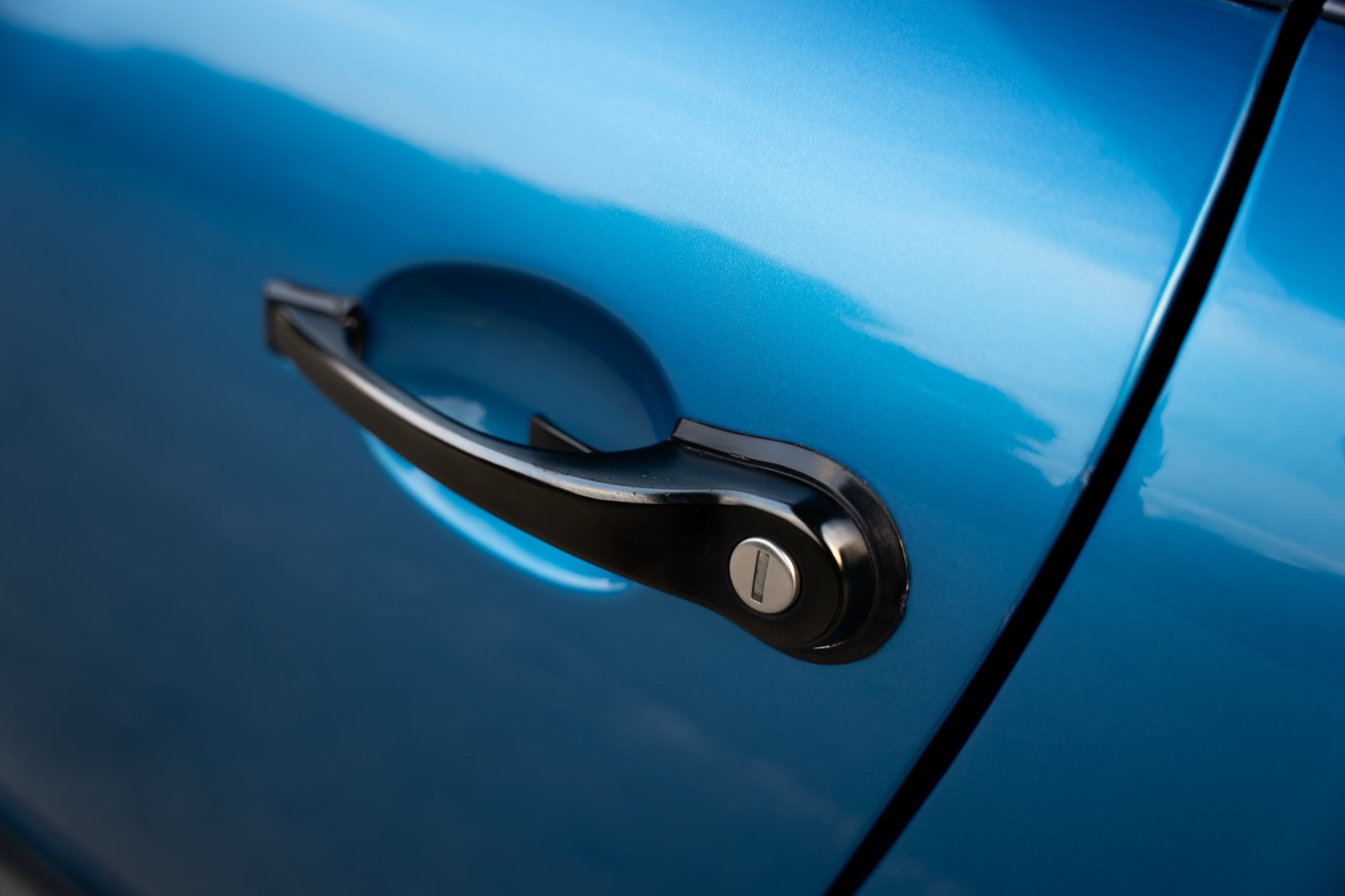 Black door handle of a blue 1980 Porsche 911 SC photographed at a steep angle along the car body