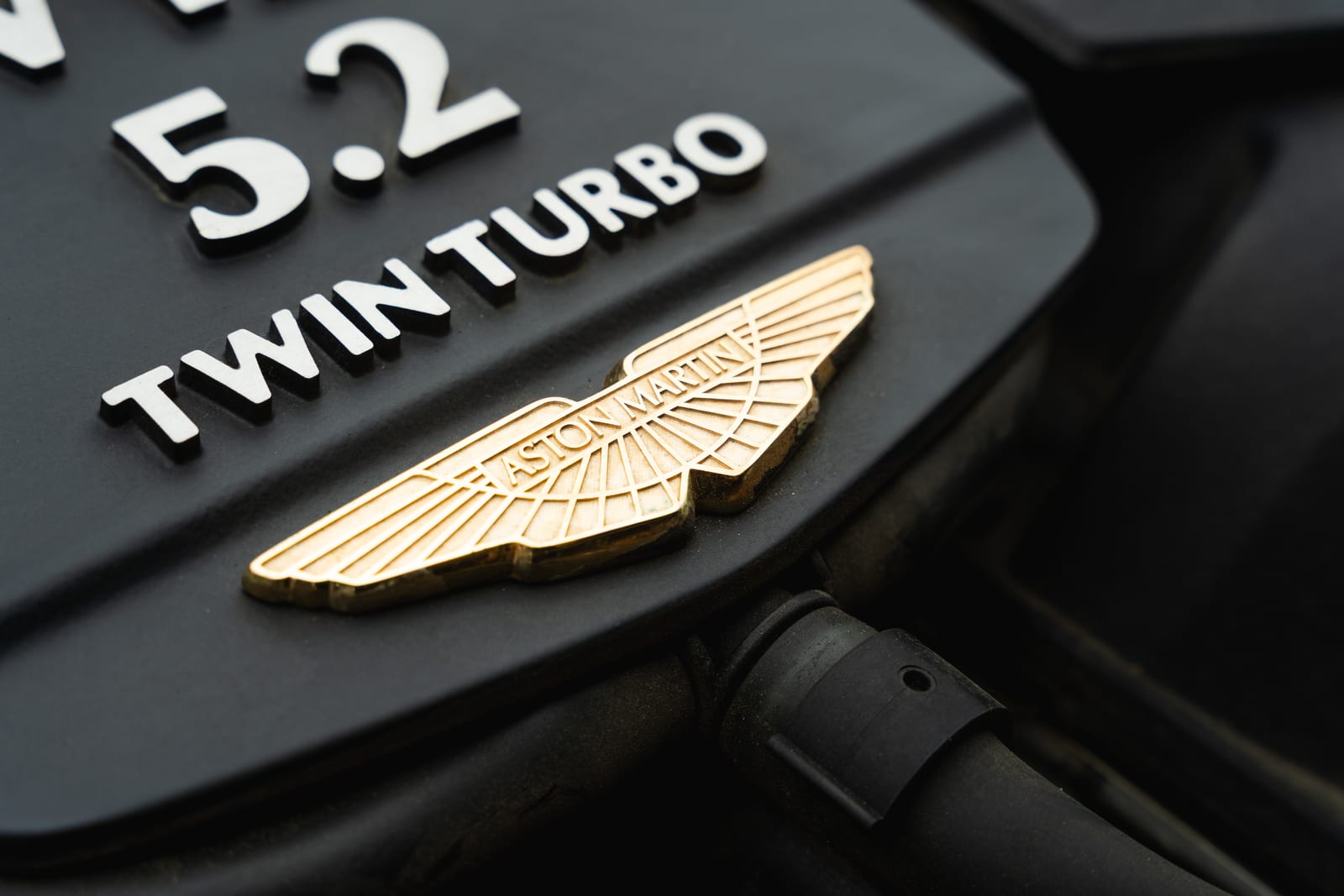 18-carat gold-plated Aston Martin wings badge beside the 5.2 Twin Turbo lettering on a 2017 DB11 engine cover