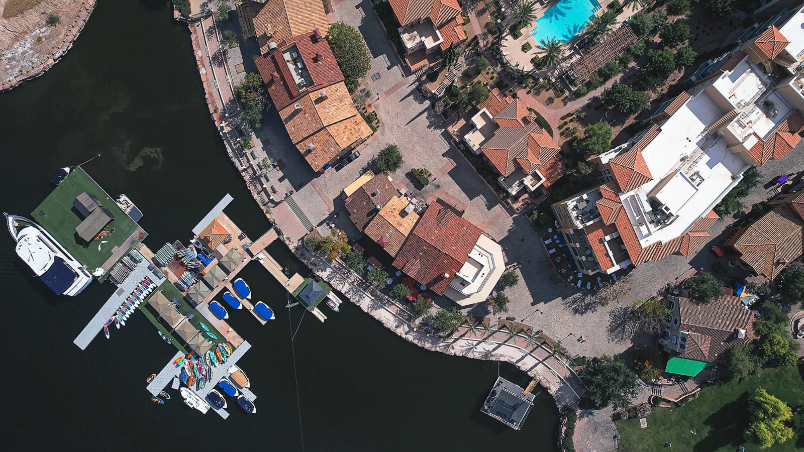 Top-down aerial of the Lake Las Vegas waterfront showing rooftops, marina docks, and pathways