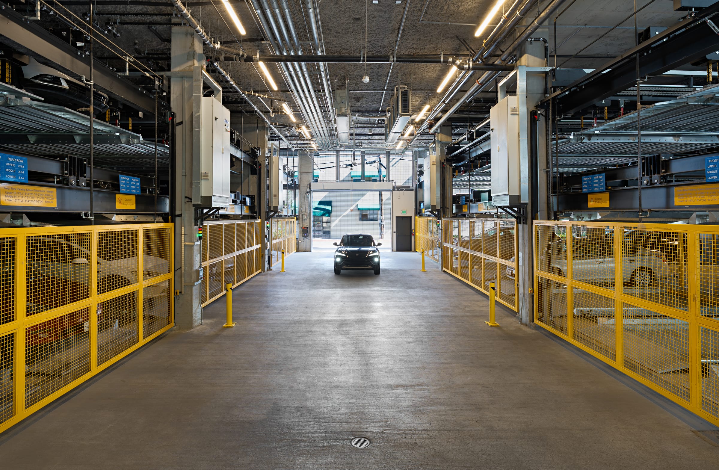 Parkworks automated parking system at Felix Apartments, Santa Rosa: the garage aisle between two rows of yellow-guarded parking platforms