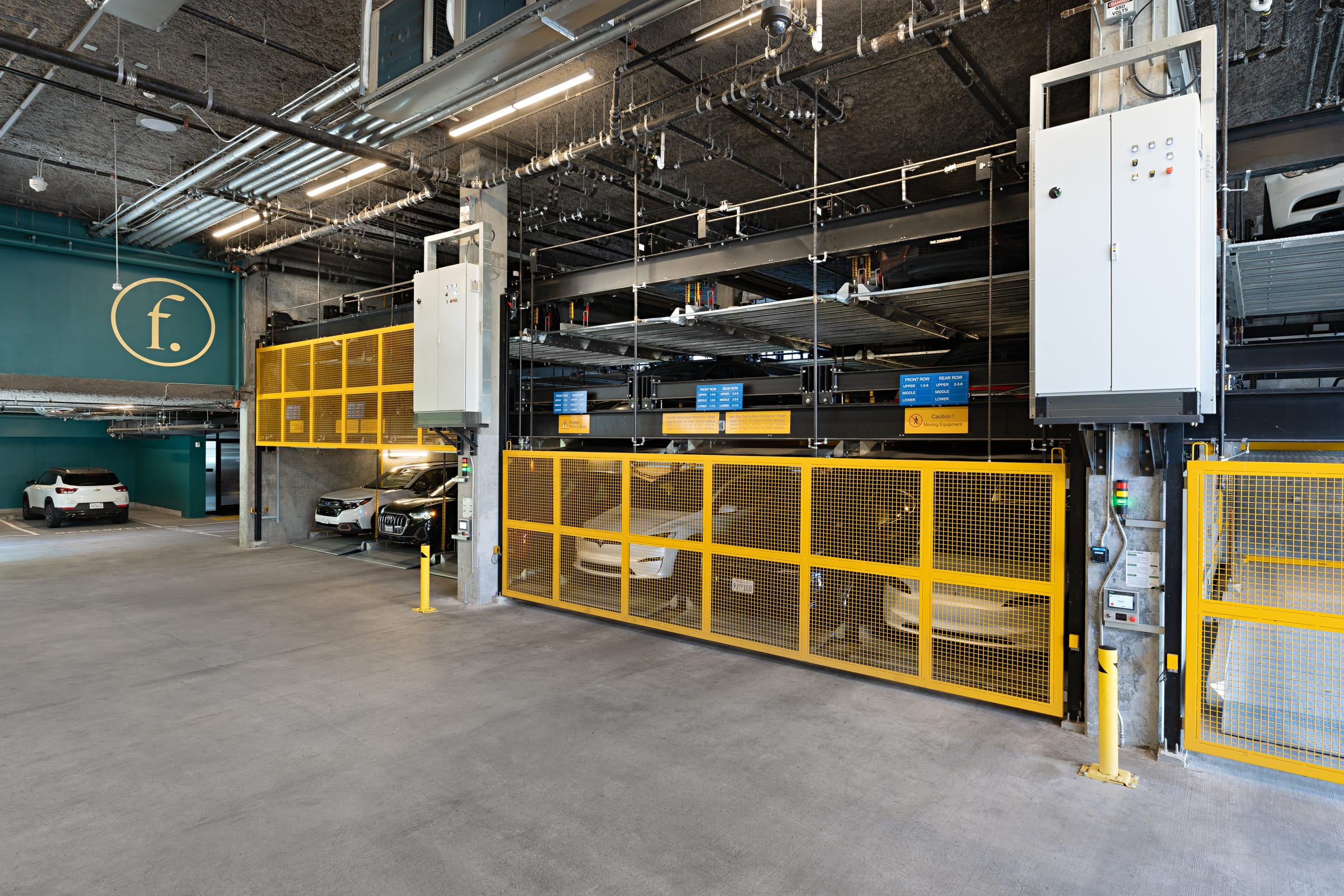 Parkworks automated parking system, Felix Apartments Santa Rosa: control cabinets and stacked platforms along the garage wall