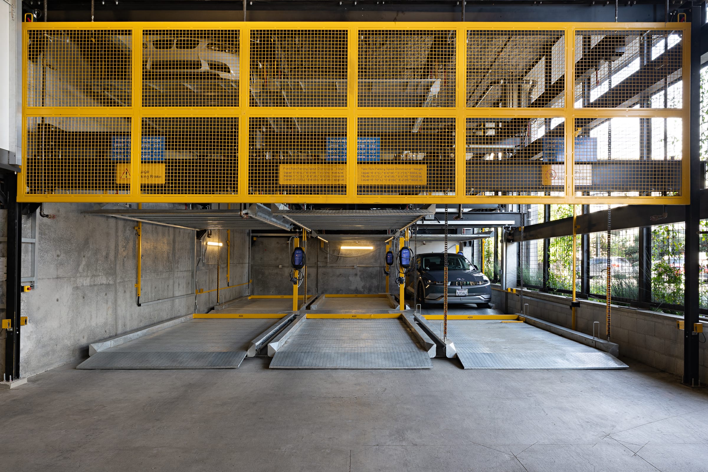 Parkworks automated parking system at Felix Apartments: platforms and upper-level pallets under the garage skylights